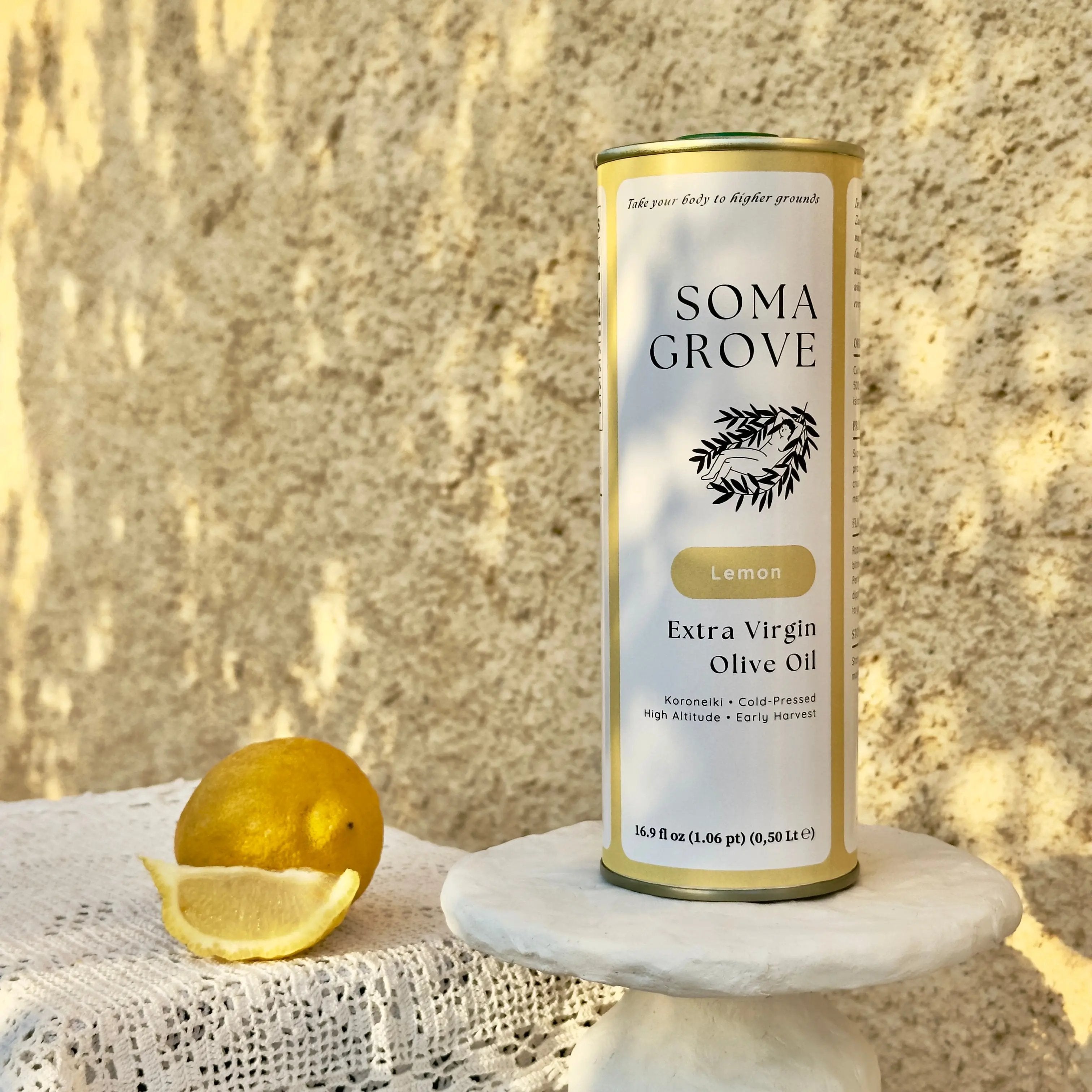 An outdoor setting with traditional Greek textiles and stone surfaces, featuring Lemon Extra Virgin Olive Oil by Soma Grove.